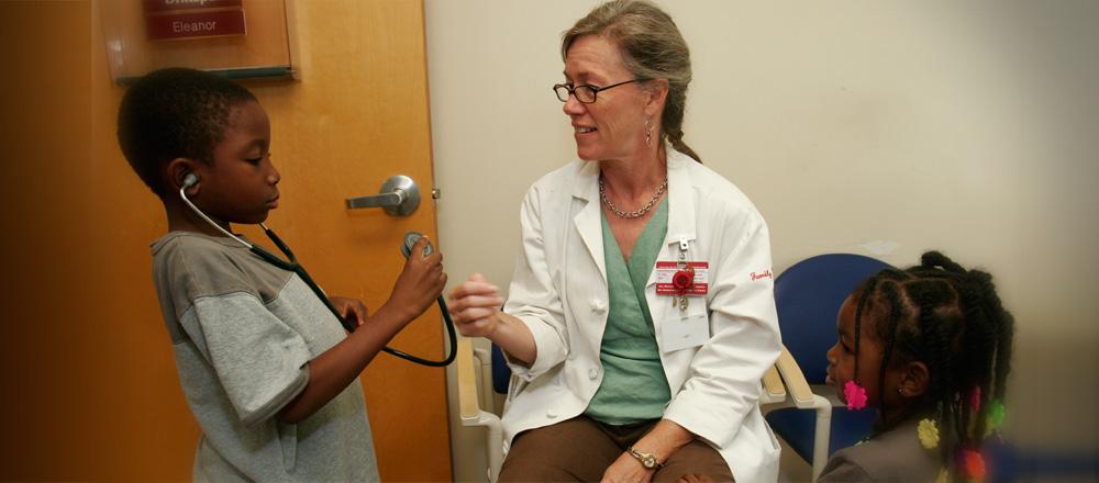 Dr. Elaine Reed with child patients in clinic